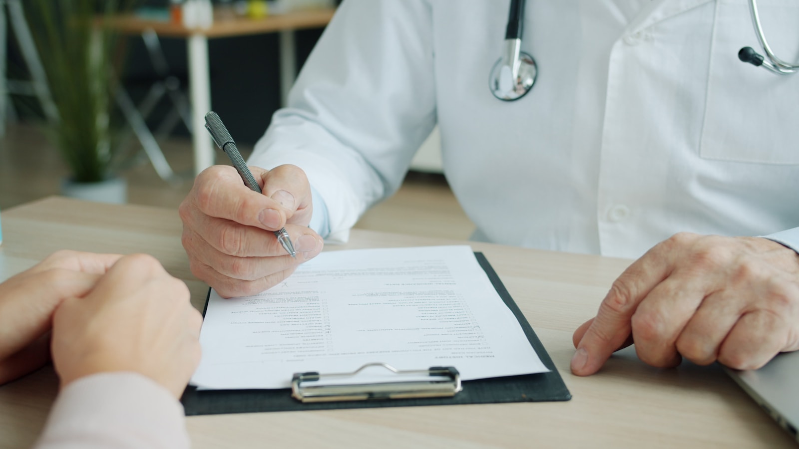 Doctor reviewing medical chart paperwork for case management support
