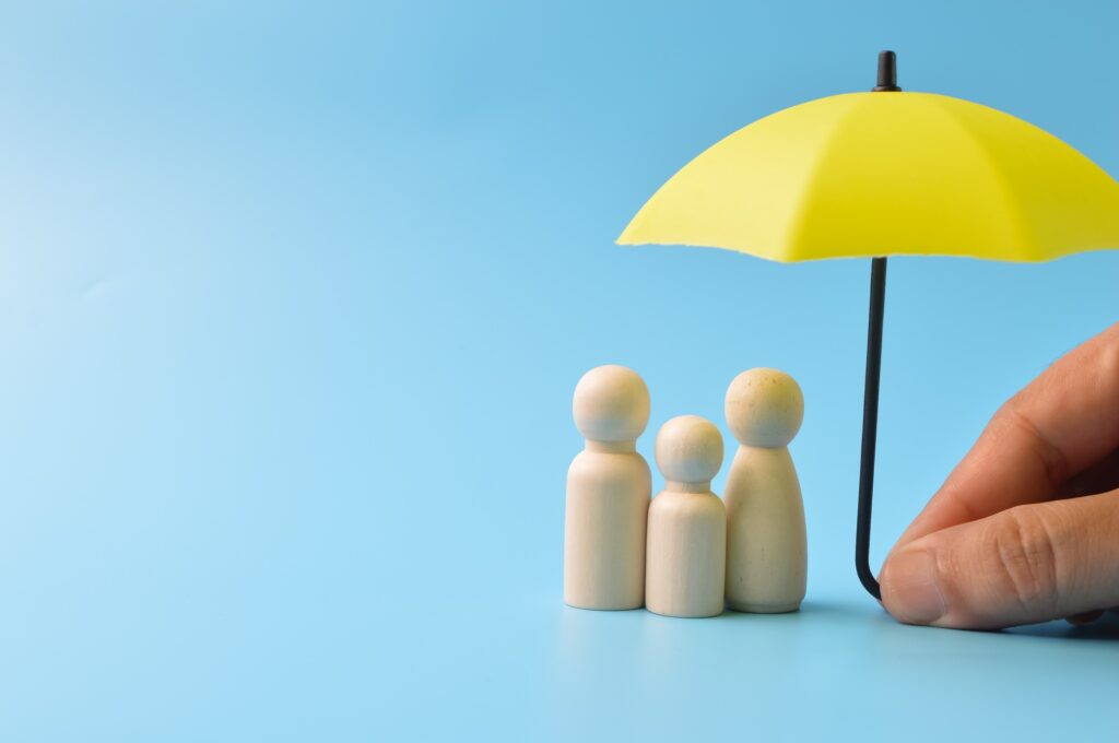 Family figures protected beneath a yellow umbrella